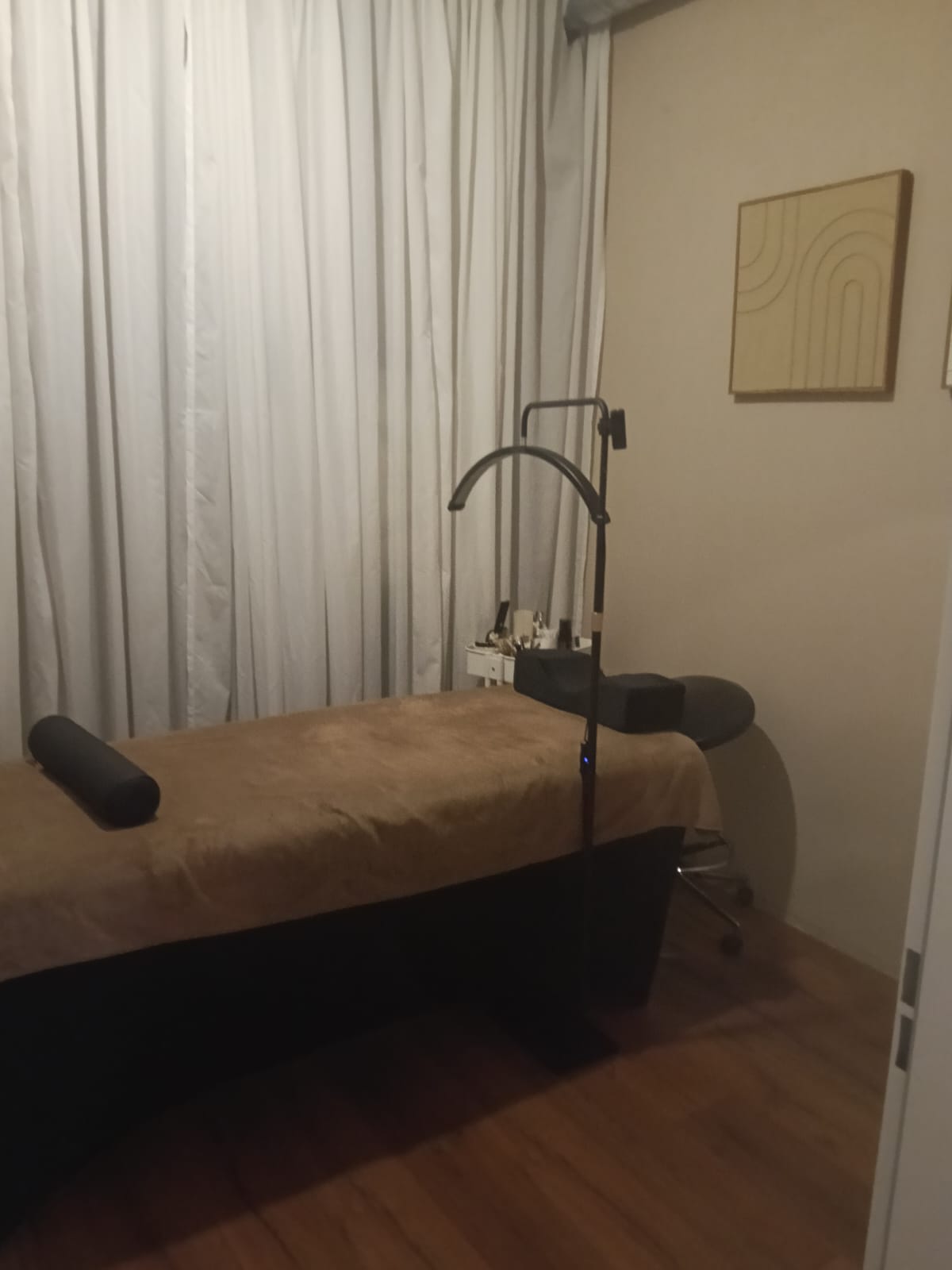Behandelruimte met behandelbank, booglamp en warme neutrale tinten in Beauty Flexsalon Eindhoven